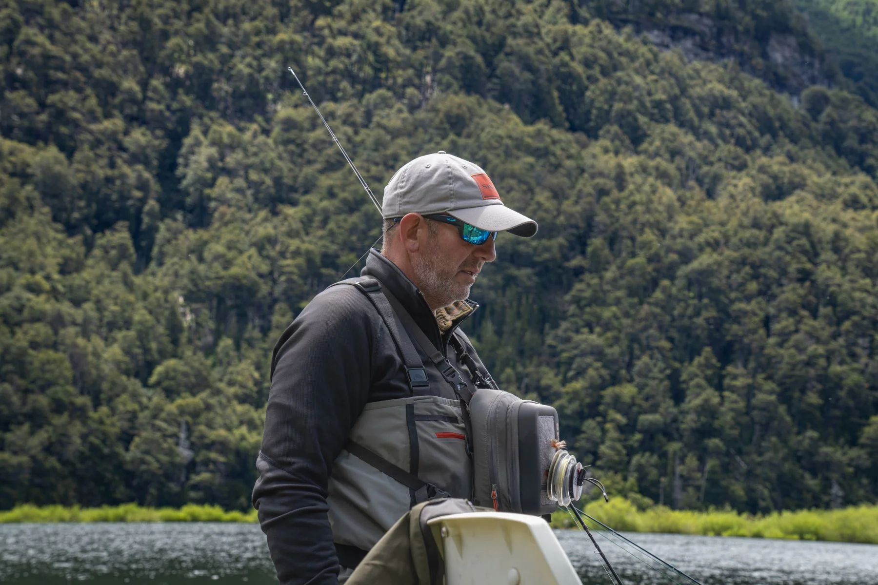 Fly angler beside clear water and greenery