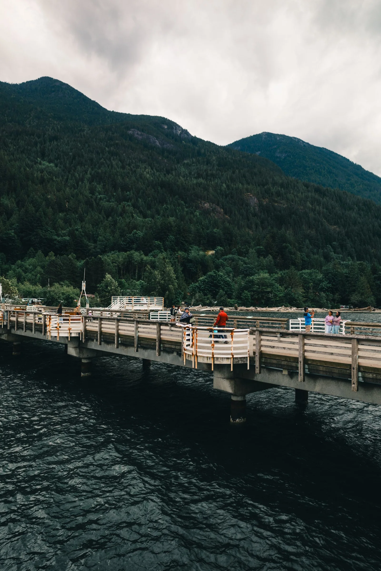 Wooden pier with forested mountains beyond