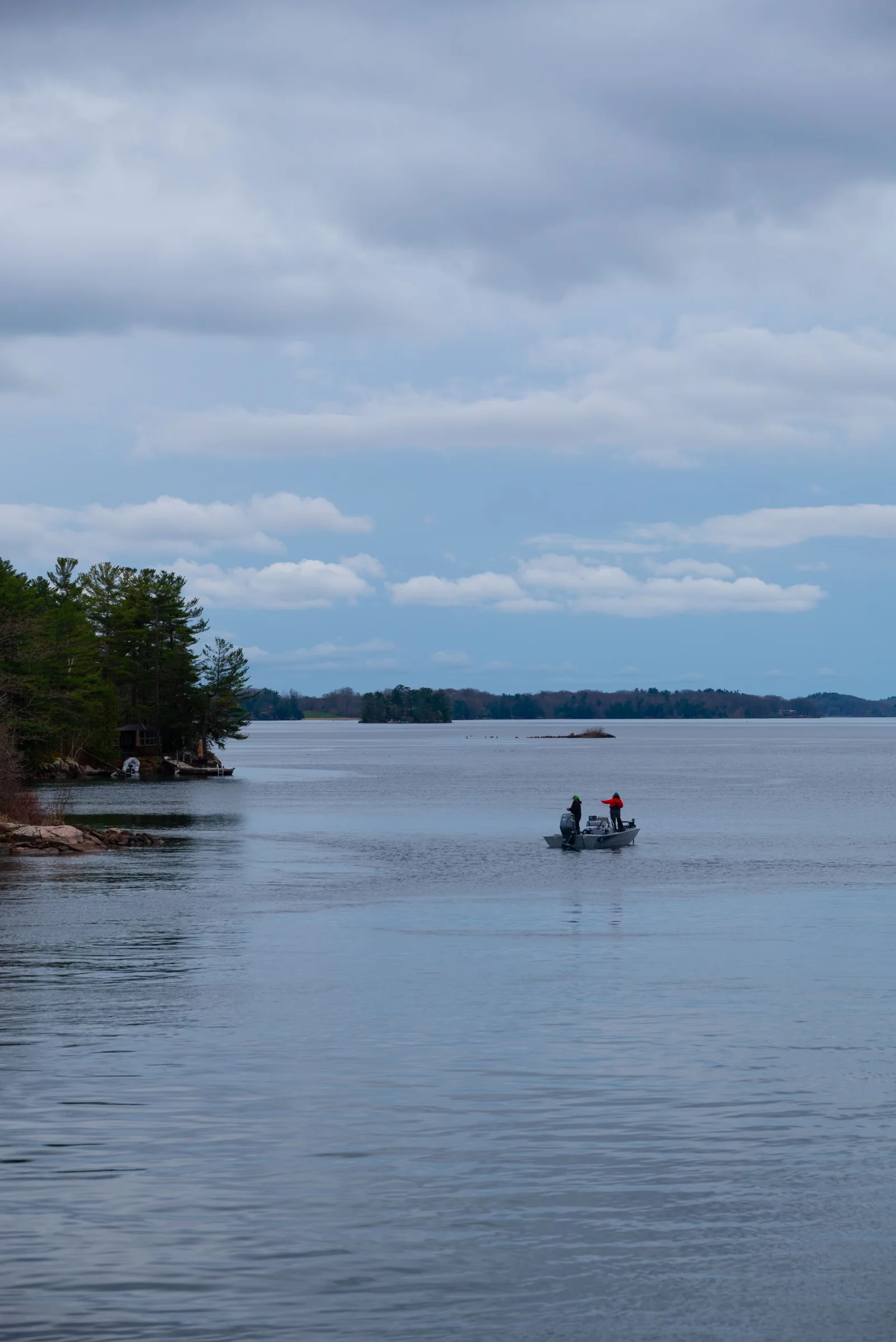 Small boat on a lake beneath cloud cover